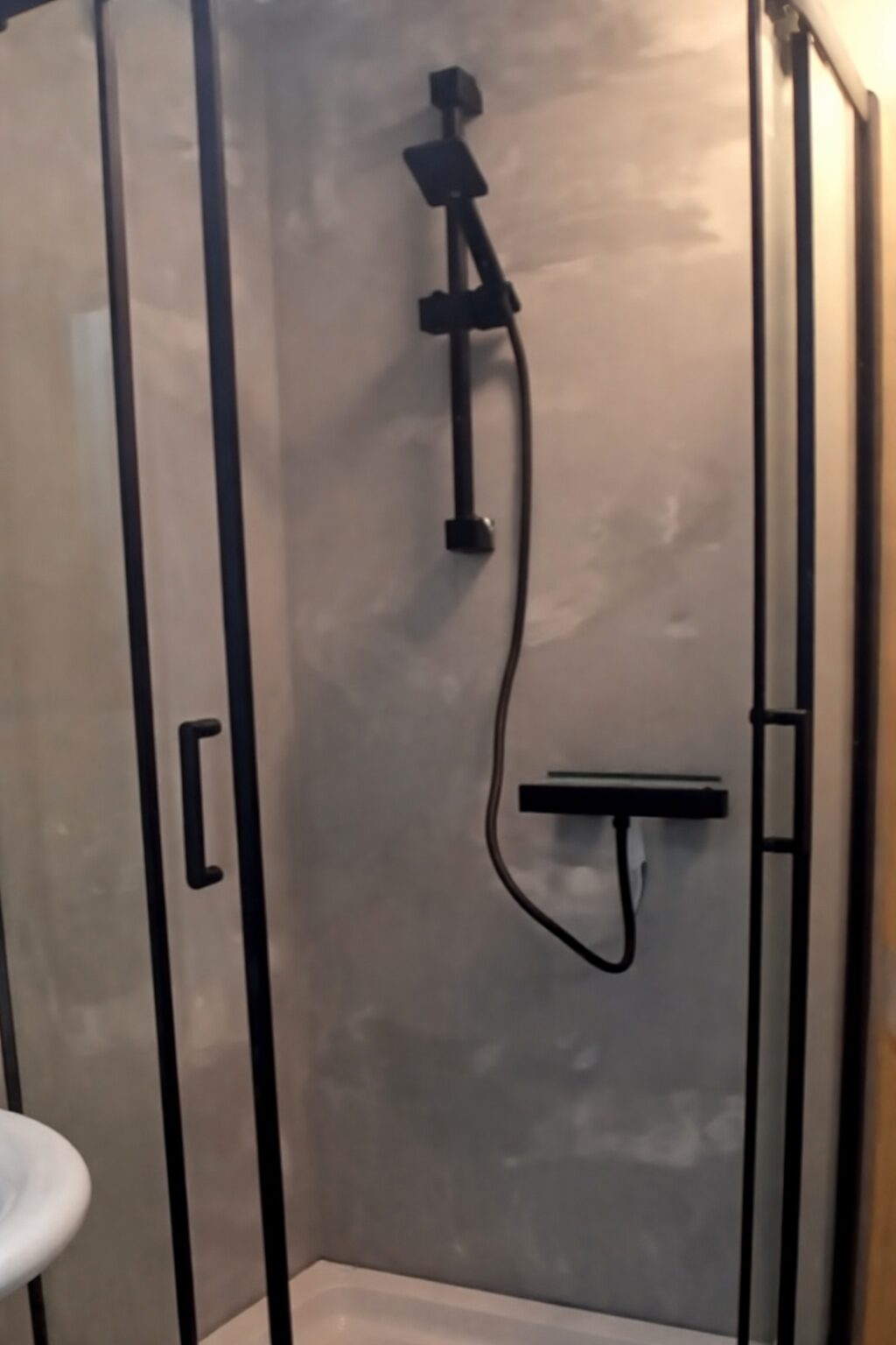 Finished grey microcement shower with black fittings