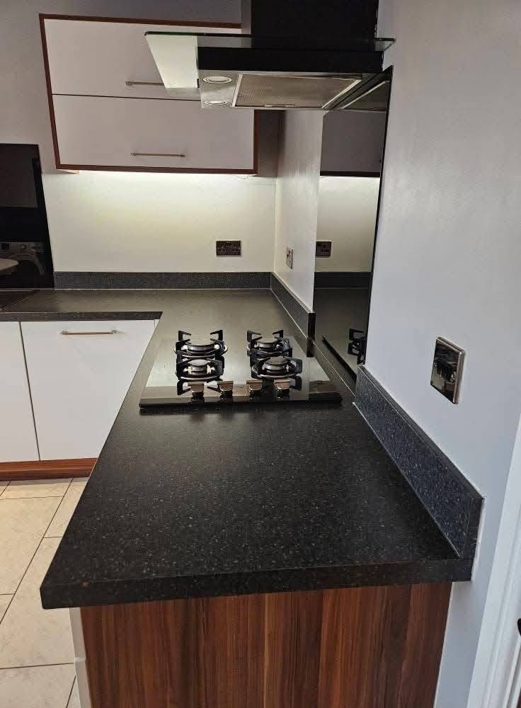 Black spray granite kitchen worktop with gas hob